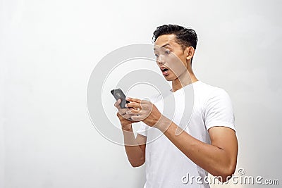 Asian man holding smartphone and shocked about discount or cash back from online shop Stock Photo