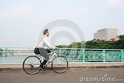 Profile image of an active businessman riding a bicycle on the w Stock Photo