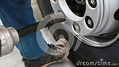 Mechanic changing truck wheel in auto repair shop by using workshop equipment tool. Stock Photo