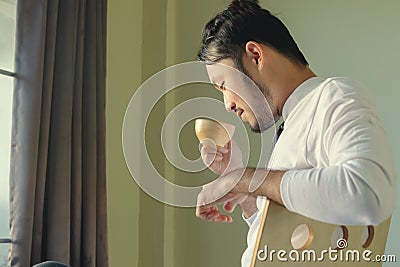 Asian man sit on chair and drink coffee with happy feel Stock Photo