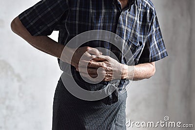 Asian man suffering from abdominal pain. It can be caused by stomach ache, enteritis, colitis, appendicitis, hepatitis, food Stock Photo