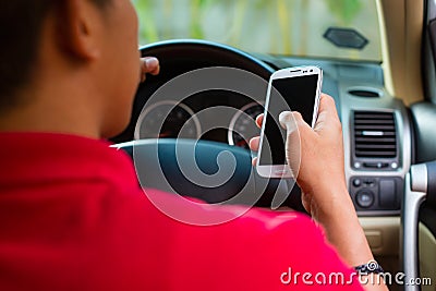 Asian man texting while driving Stock Photo