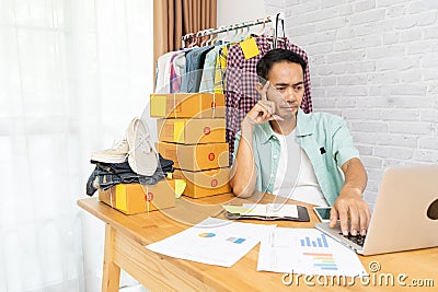 Asian man think hard serious working laptop computer at home selling online Stock Photo