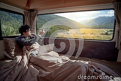 Asian man traveler taking photo in camper van Stock Photo