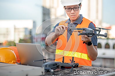 Asian man using drone and laptop for construction site survey Stock Photo