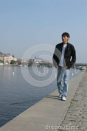 Asian Man Walking along the Embankment Stock Photo