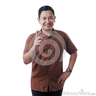 Asian Man Wearing Batik Shirt Raising Pointing Finger, Number One Stock Photo