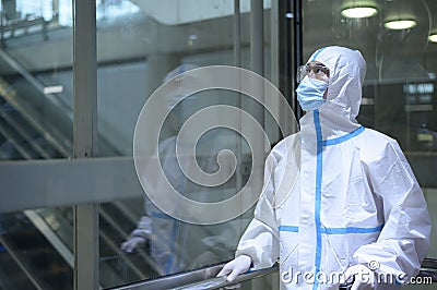 An Asian man is wearing ppe suit in airport elevator , Safety travel , covid-19 protection , social distancing concept Stock Photo