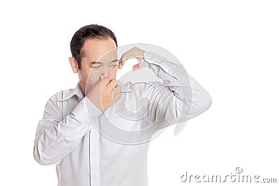Asian man wearing shirt disgusting with bad smell of his wet arm Stock Photo