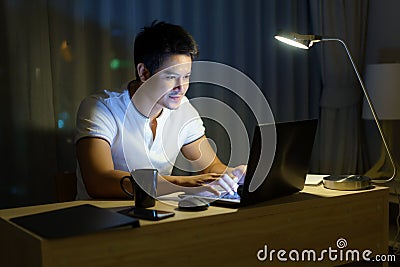 Asian man working at home are sitting in front of a computer late at night Stock Photo