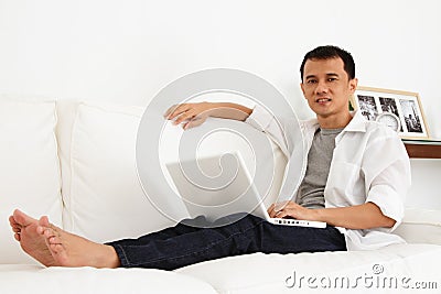 Asian Man Working on Laptop at Home Stock Photo