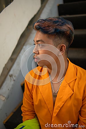 an Asian man in a yellow suit is standing on a broken elevator Stock Photo