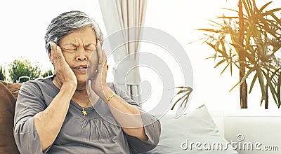Asian Mature woman with elderly woman with headache takes a pill Stock Photo