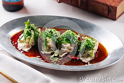 Asian meat stuffed dumplings with sauce in a bowl Stock Photo