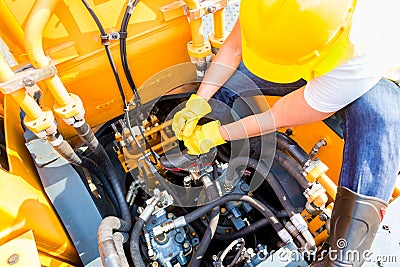 Asian mechanic repairing construction vehicle Stock Photo