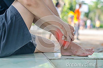 Asian men health care.he is holding her ankle in pain Stock Photo