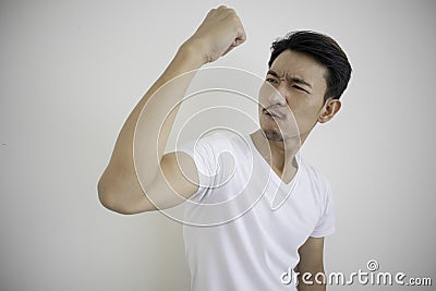 Asian men wearing white t-shirts Raising fist in right hand Showing signs of joy Stock Photo