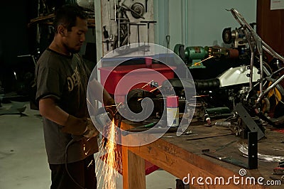 Asian Men at work grinding steel Editorial Stock Photo