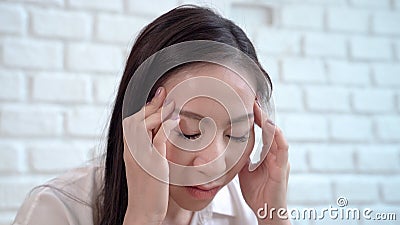 Asian middle-aged women are hold the head with hand to headaches from hopeless fatigue Stock Photo