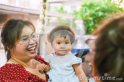 Asian mom smile laugh newborn baby kid eye contact mom smiling cuteness children happy family soft mattress living life healthy Stock Photo