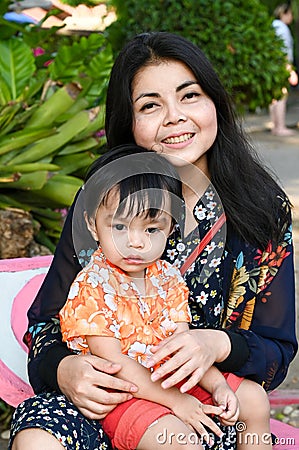 Asian mother and child happily cuddle and tease each other Stock Photo