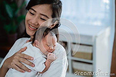 Asian mother embrace carrying newborn little daughter Stock Photo