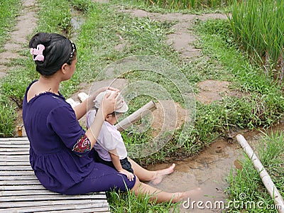 Asian mother and her little baby girl enjoy spending time together in a rice field Stock Photo