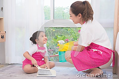 Mother teaching daughter cleaning their home Stock Photo