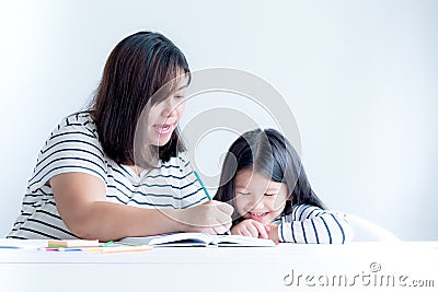 Asian mother is teaching a 6 year old daughter to learn to write and read Stock Photo