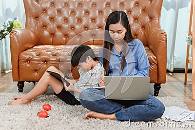 Asian mother work home. Mom together with son. Kid online learning education. New normal lifestyle and family Stock Photo