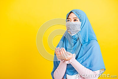 Woman wear hijab and face mask she henna decorated hands praying Stock Photo