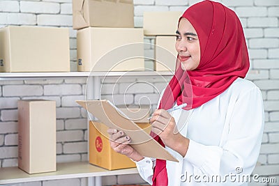 Asia Muslim businesswoman, SME owners inspect products in stock. Stock Photo