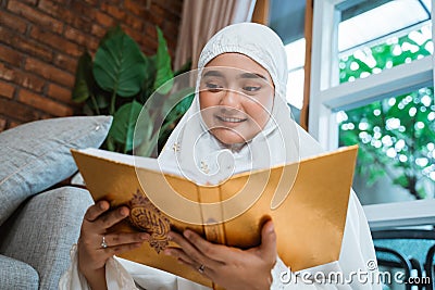 Muslim woman reading al quran Stock Photo