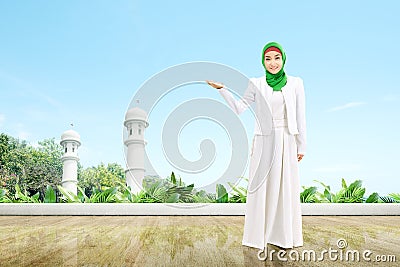 Asian Muslim woman in a veil standing and showing open palm Stock Photo