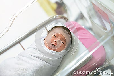 Asian newborn baby in bassinet at delivery room at hospital Stock Photo