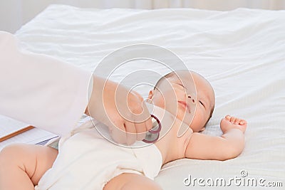 Asian newborn baby get sick sleep during examine by pediatrician doctor hand hold stethoscope, Little child in medicine hospital. Stock Photo