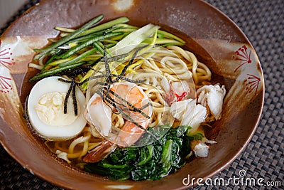 Asian noodle soup with meat, boiled egg, shrimp, spinach. Closeup with selective focus Stock Photo