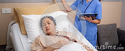 Asian nurse check saline and check patient elderly while asleep on bed at hospital ward, doctor diagnostic senior woman. Stock Photo