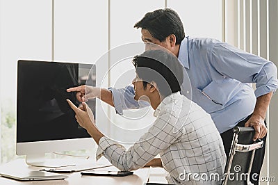 Asian old senior male father stand and young handsome teen son sit use index finger pointing blank empty black computer monitor Stock Photo