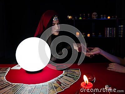 Asian palmist woman reading line on hand fate and spread tarot cards for client choose one from the set Stock Photo