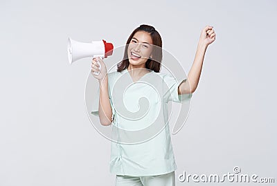 Asian patient woman wearing patient gown shouting loud holding a megaphone speaking for compensation coverage or tell insurance Stock Photo