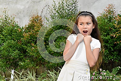 A Fearful Youthful Philippina Kid Outdoors Stock Photo