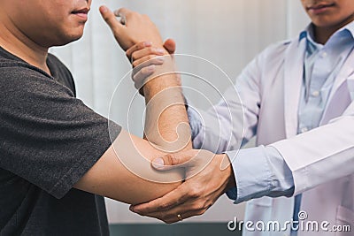 Asian physiotherapists check the elbows of patients who have undergone orthopedic rehabilitation Stock Photo