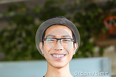 Asian positive cheerful young man in glasses Stock Photo