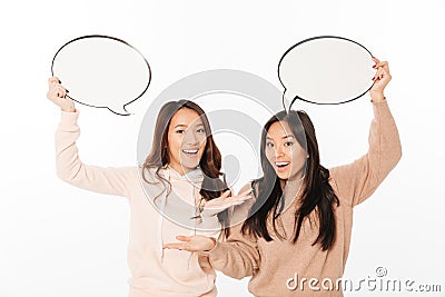 Asian positive ladies sisters holding speech bubbles. Stock Photo