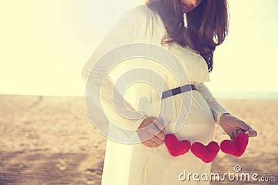 Asian pregnant woman holding heart shape accessories Stock Photo