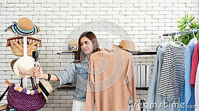 Asian pretty influencer girl selfie live video with action camera and review beige sweater for sell online Stock Photo