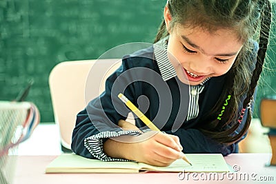 Asian primary school student studying homework in classroom Stock Photo