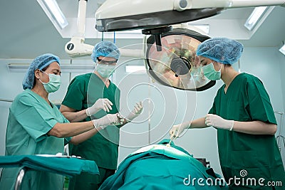 Asian Professional surgeons team performing surgery in the operating room, surgeon, Assistants, and Nurses Performing Surgery on a Stock Photo