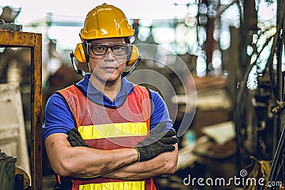 Asian Professional worker standing arm cross in heavy industry working in factory production line process with eyes and ears Stock Photo